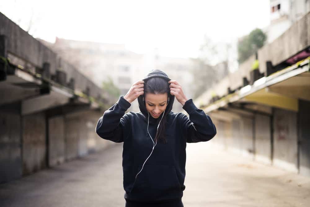 Female athlete putting the hood on.