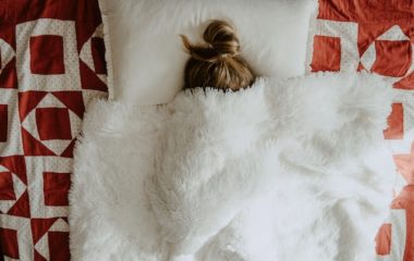 girl hiding under blankets